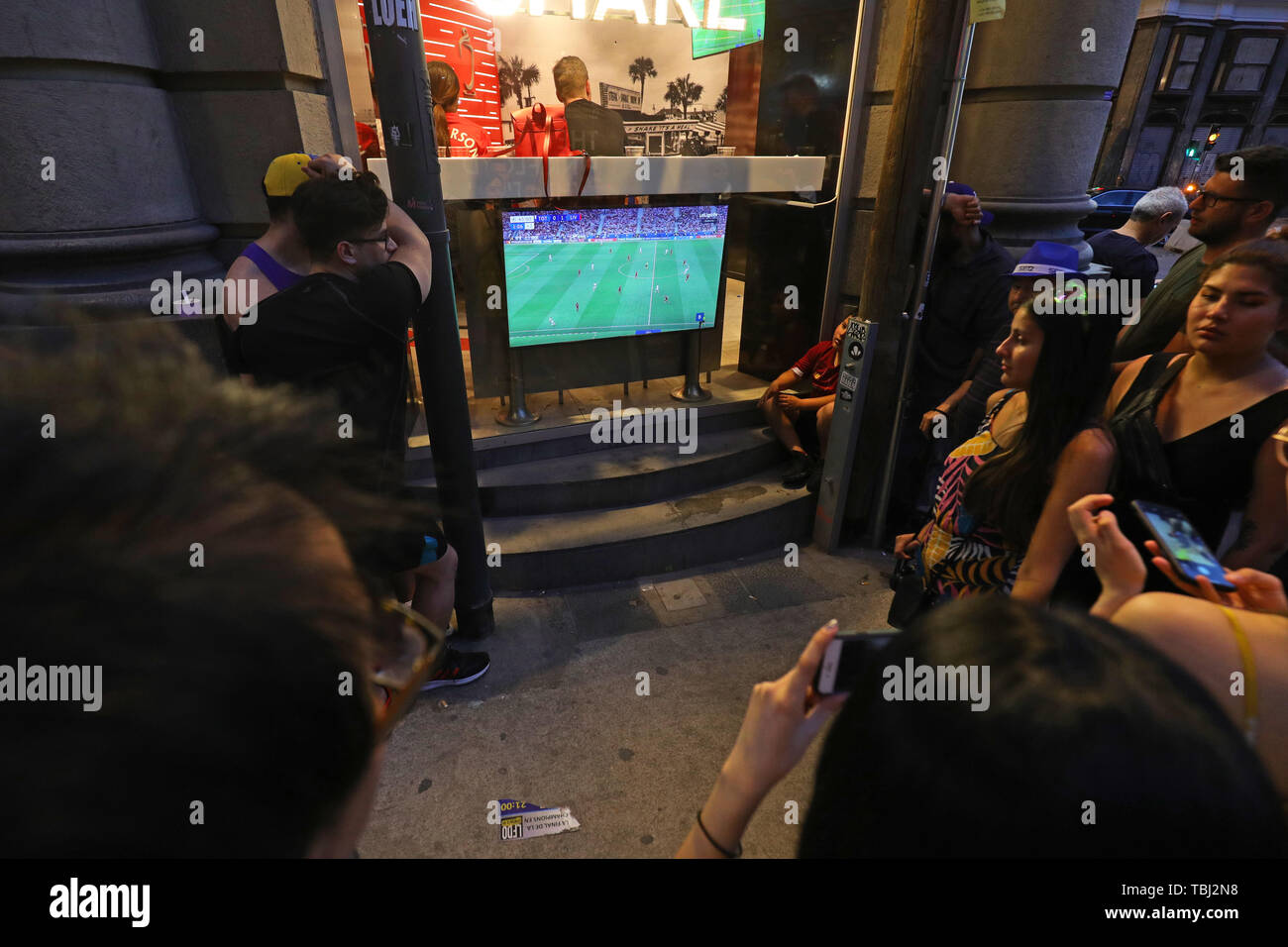 People watch the Champions League final between Liverpool and Tottenham Hotspur on a TV ona street corner in Madrid Stock Photo Alamy