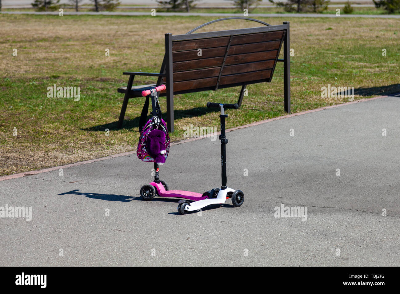 Two Small Pink And White Children S Scooters Are Standing Nearby