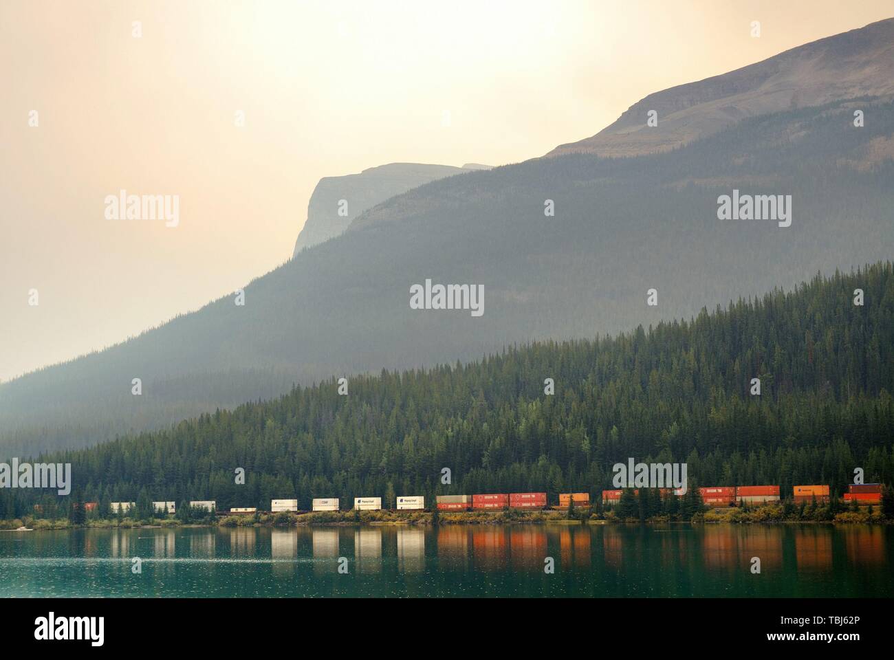 BANFF, CANADA - AUGUST 27: Cargo train lake and mountain on August 27, 2015 in Banff National Park, Canada. Established in 1885, it is the oldest park in Canada. Stock Photo