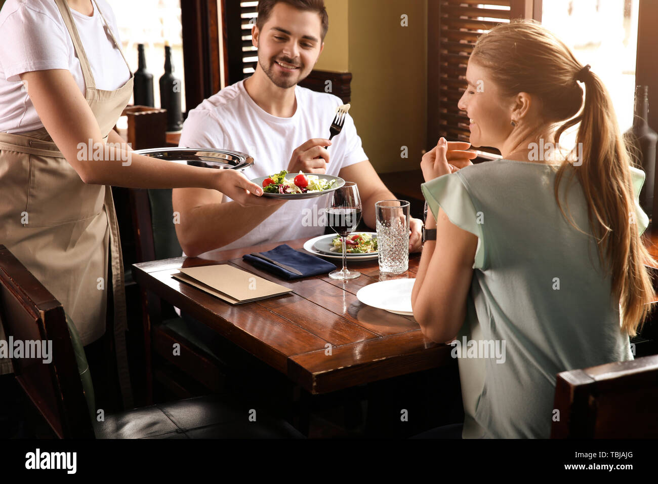 Waiter serving guests in restaurant Stock Photo Alamy