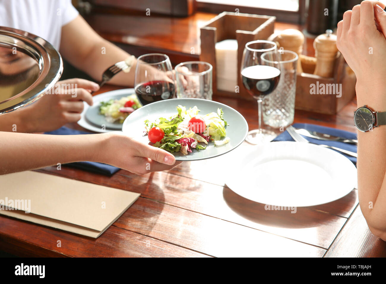 Waiter serving guests in restaurant Stock Photo Alamy
