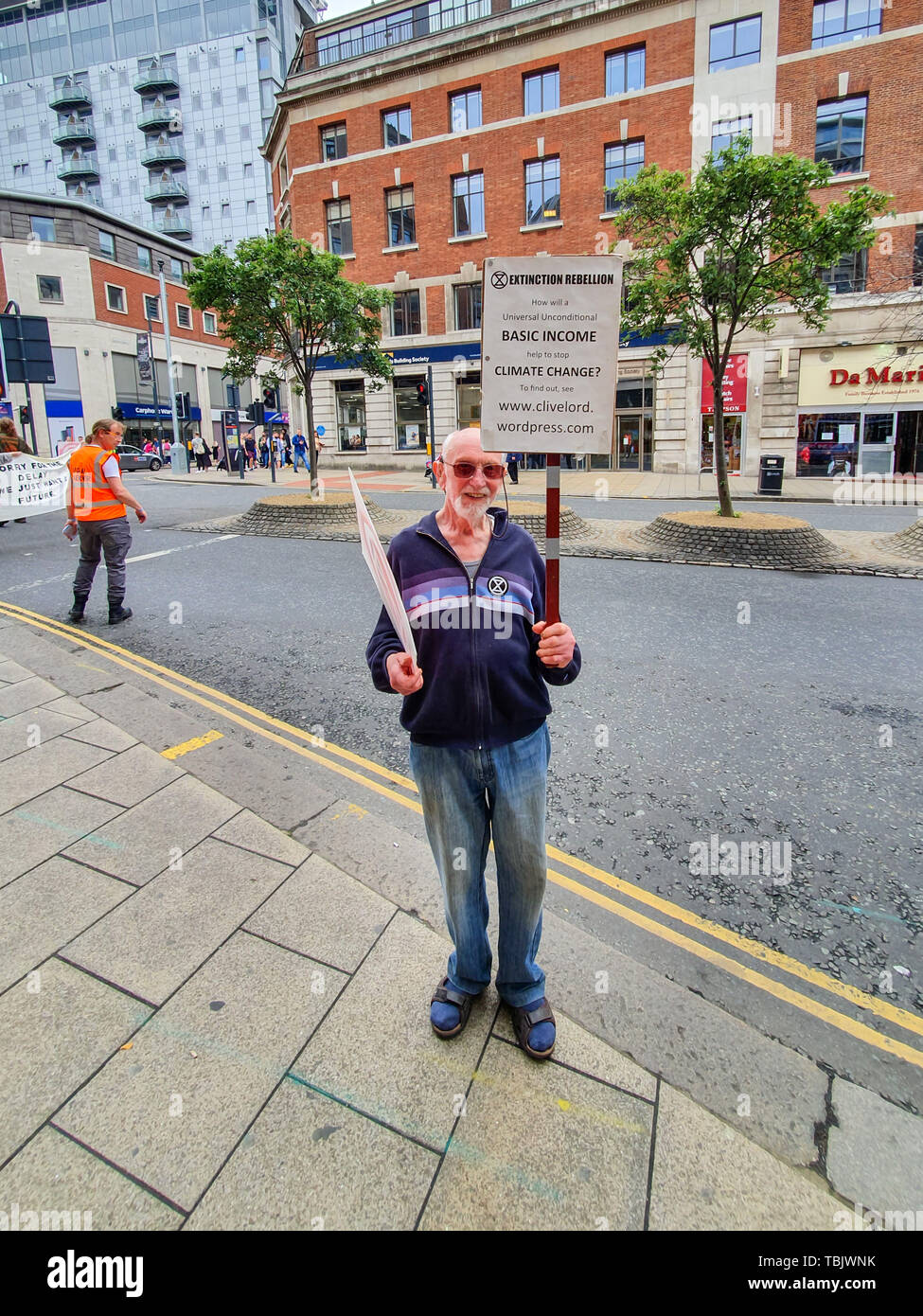 Elderly man protests about climate change in Leeds city centre holding signs up Stock Photo