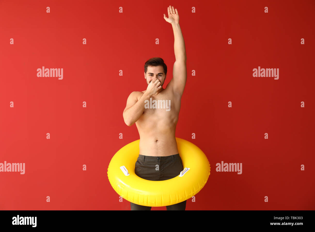 Handsome man with inflatable ring on color background Stock Photo