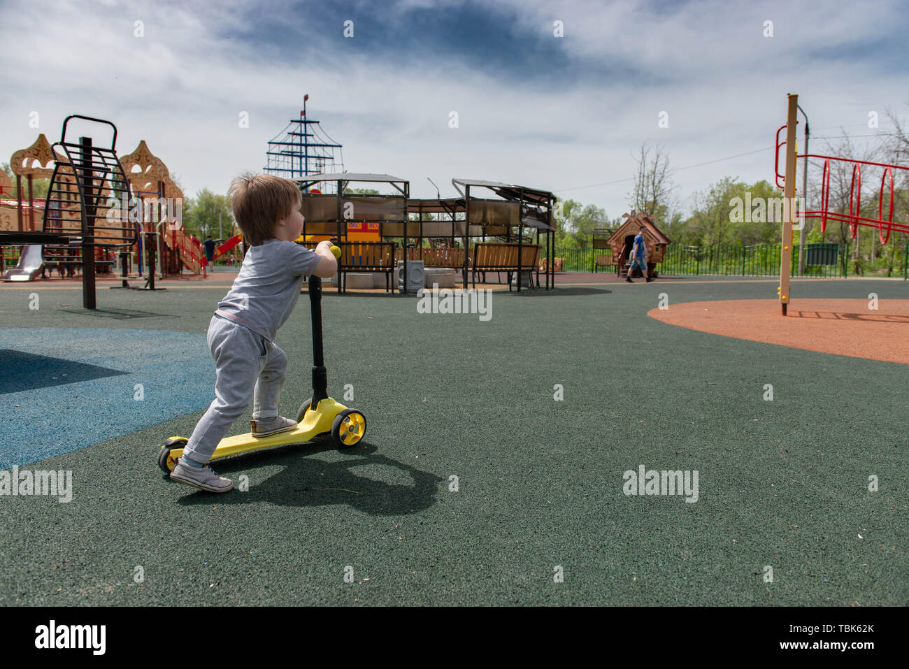 boy on the playground riding a scooter Stock Photo