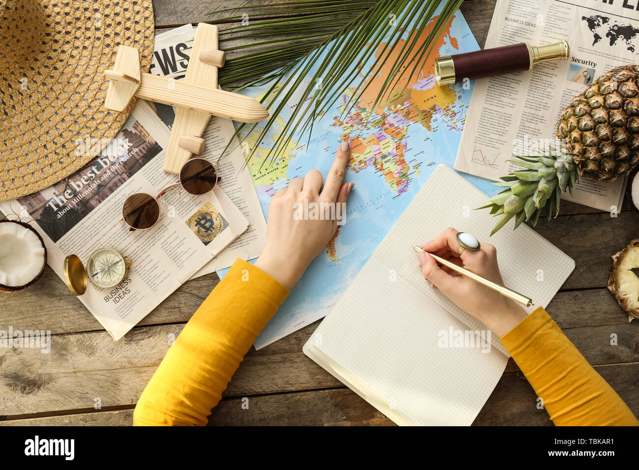 Young woman with world map choosing country to spend her vacation Stock Photo
