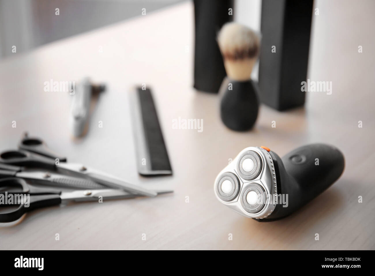 Electric shaver with tools on table Stock Photo