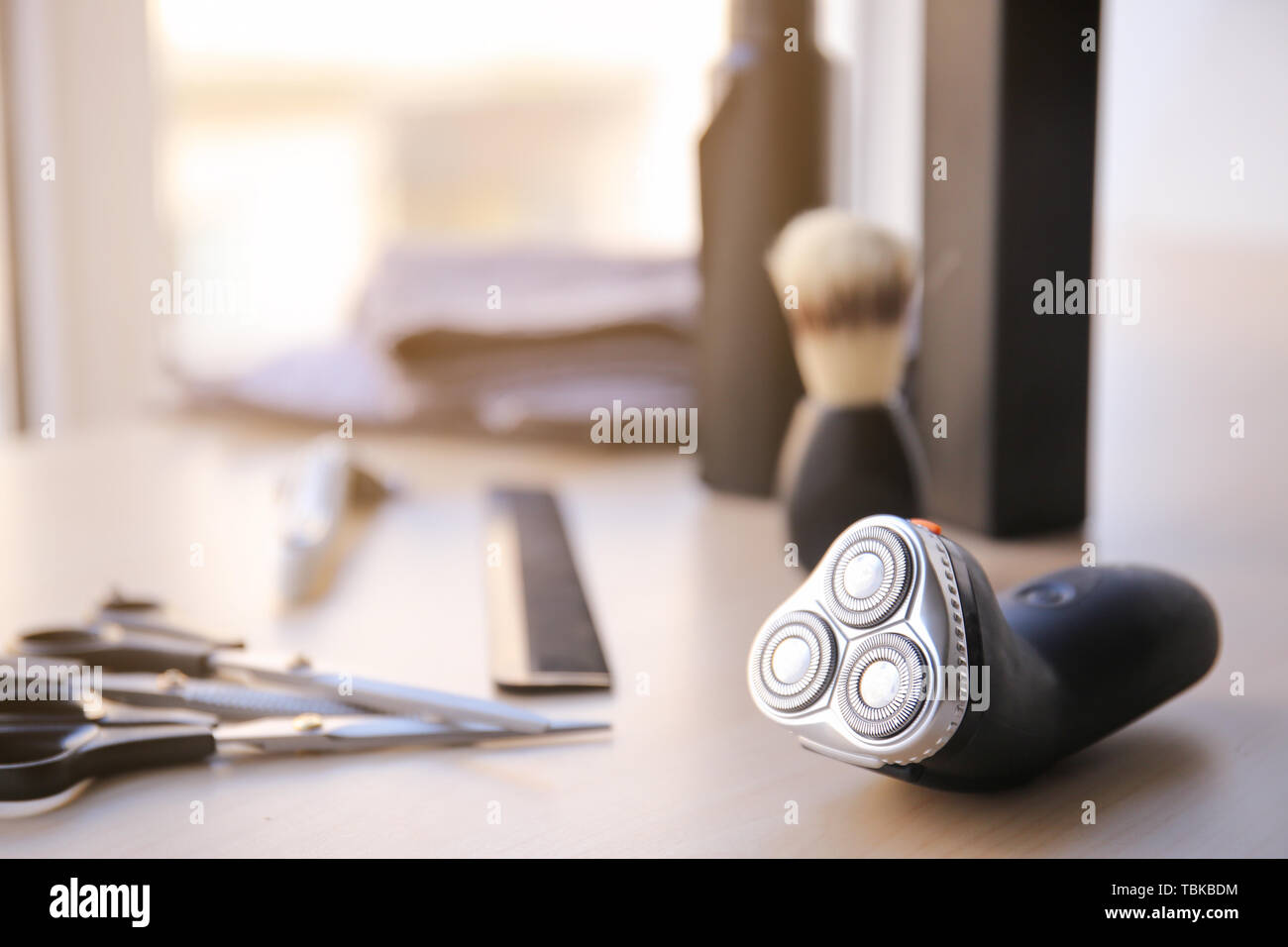 Electric shaver with tools on table Stock Photo