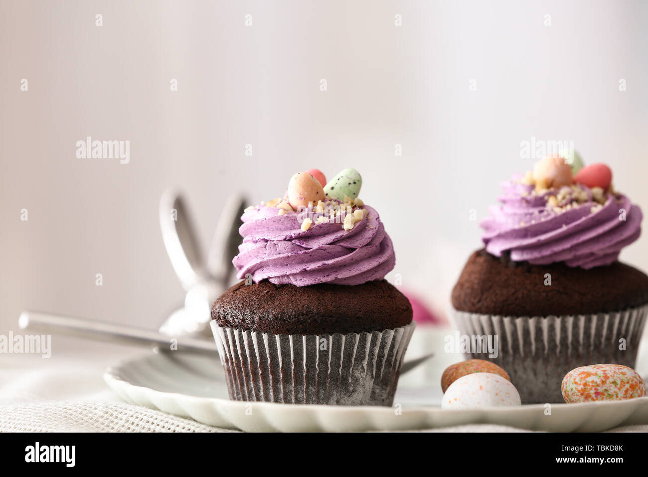 Tasty Easter cupcakes on plate Stock Photo