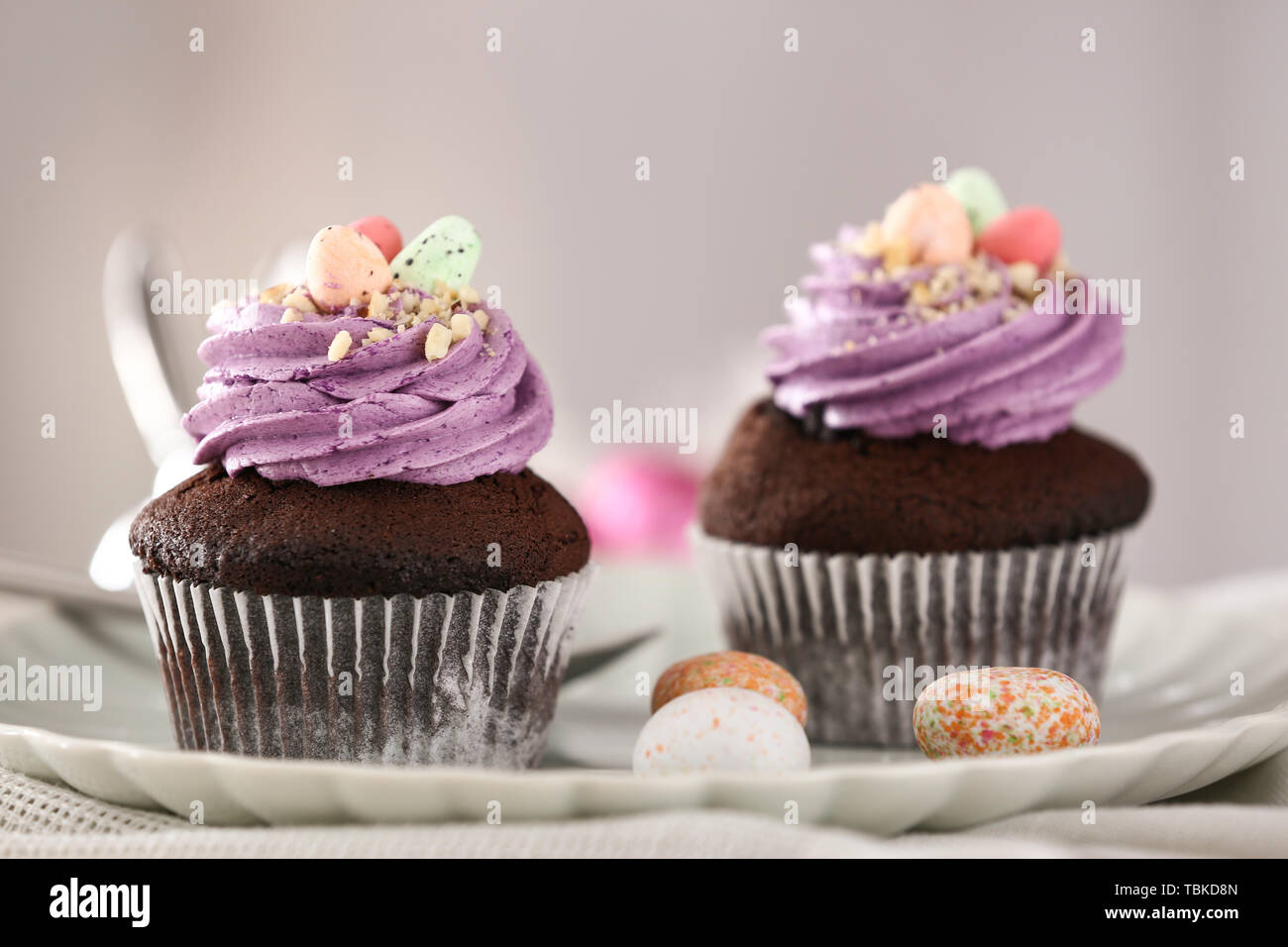 Tasty Easter cupcakes on plate Stock Photo
