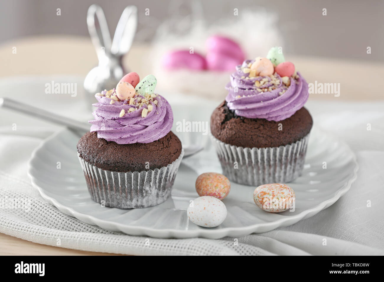 Tasty Easter cupcakes on plate Stock Photo