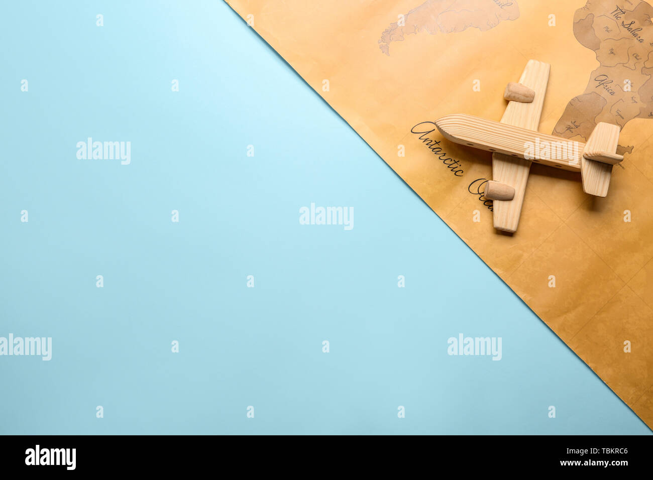 Toy airplane with world map on - Toy Airplane With World Map On Color Background Travel Concept TBKRC6