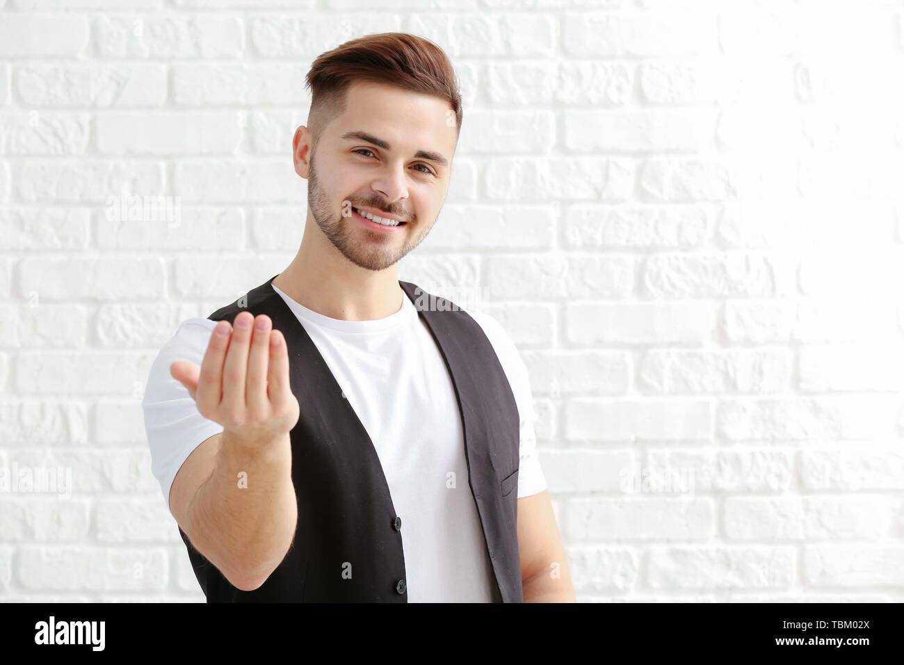 Handsome man showing quot come here quot gesture on white background Stock Handsome man showing quot come here quot gesture on white background Stock