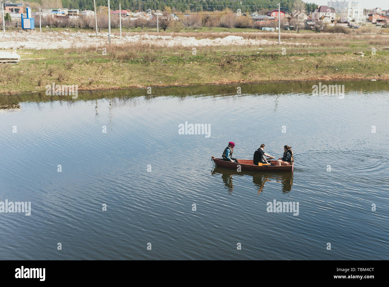 Three friends in a boat are crossing the river. River rafting. Stock Photo