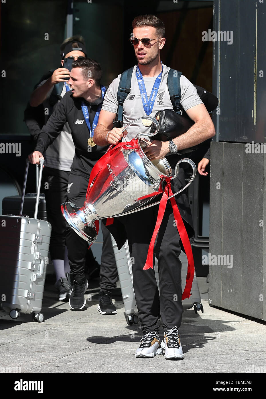 Liverpool's Jordan Henderson with the trophy leaves the Eurostars Madrid Tower Hotel, as the team travel home for a homecoming parade. Stock Photo