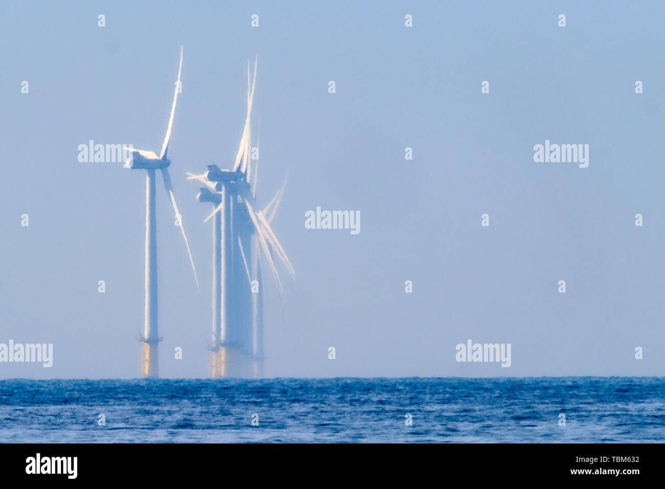 Rampion Wind Farm in the hazy morning sun on Sunday 2 June 2019 as photographed from Worthing Beach, Worthing. Rampion is an offshore wind farm, over 8 miles from the shore, development by E.ON, off the Sussex coast in the UK. The wind farm has a capacity of 400 MW. The wind farm was commissioned in April 2018. Picture by Julie Edwards. Stock Photo