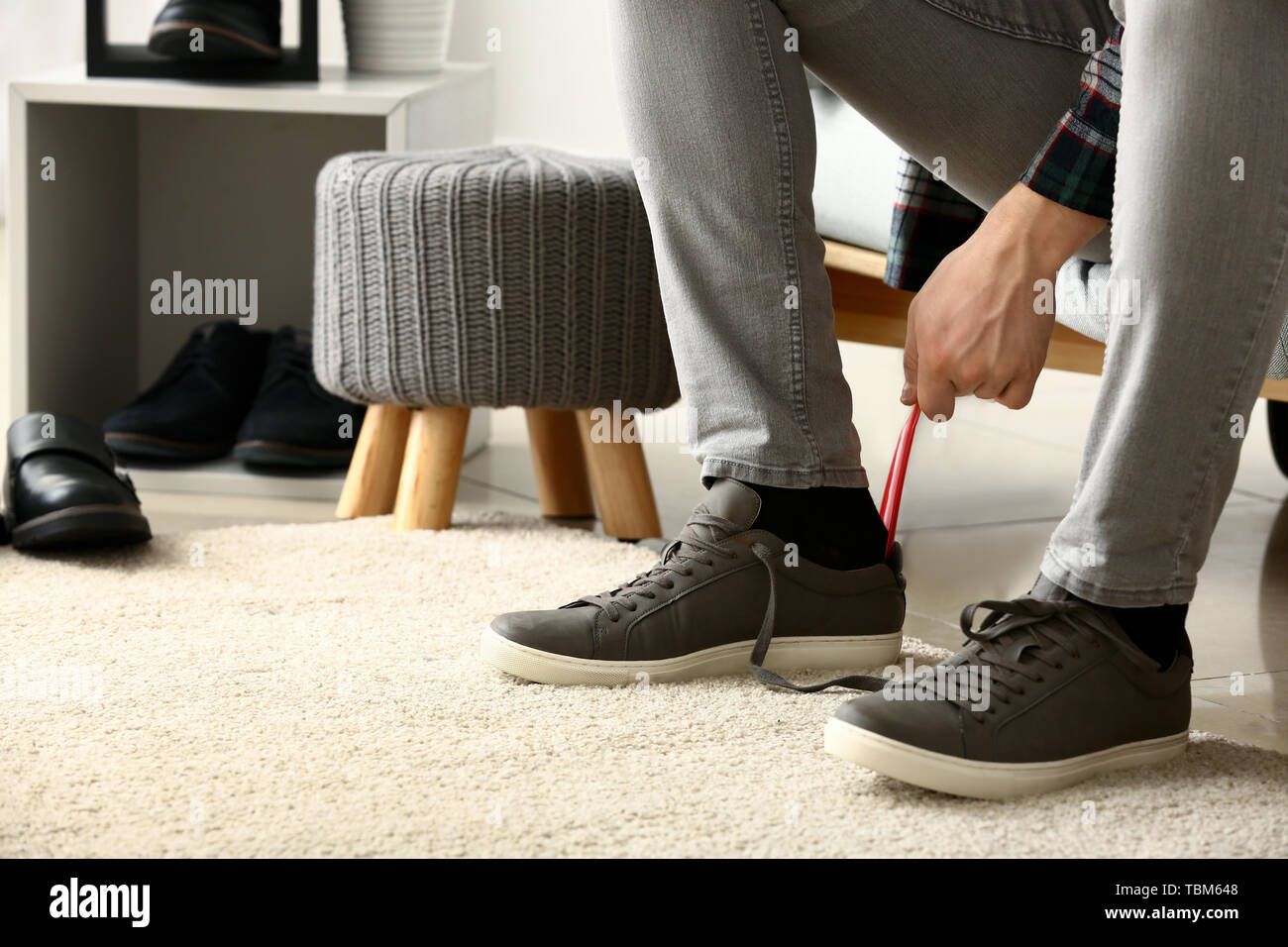 Young man putting on shoes in dressing room Stock Photo Alamy