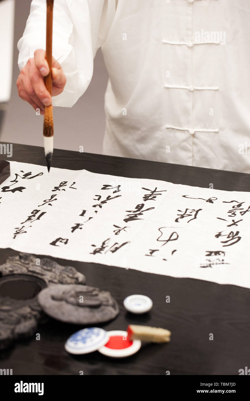 An old man practicing calligraphy Stock Photo