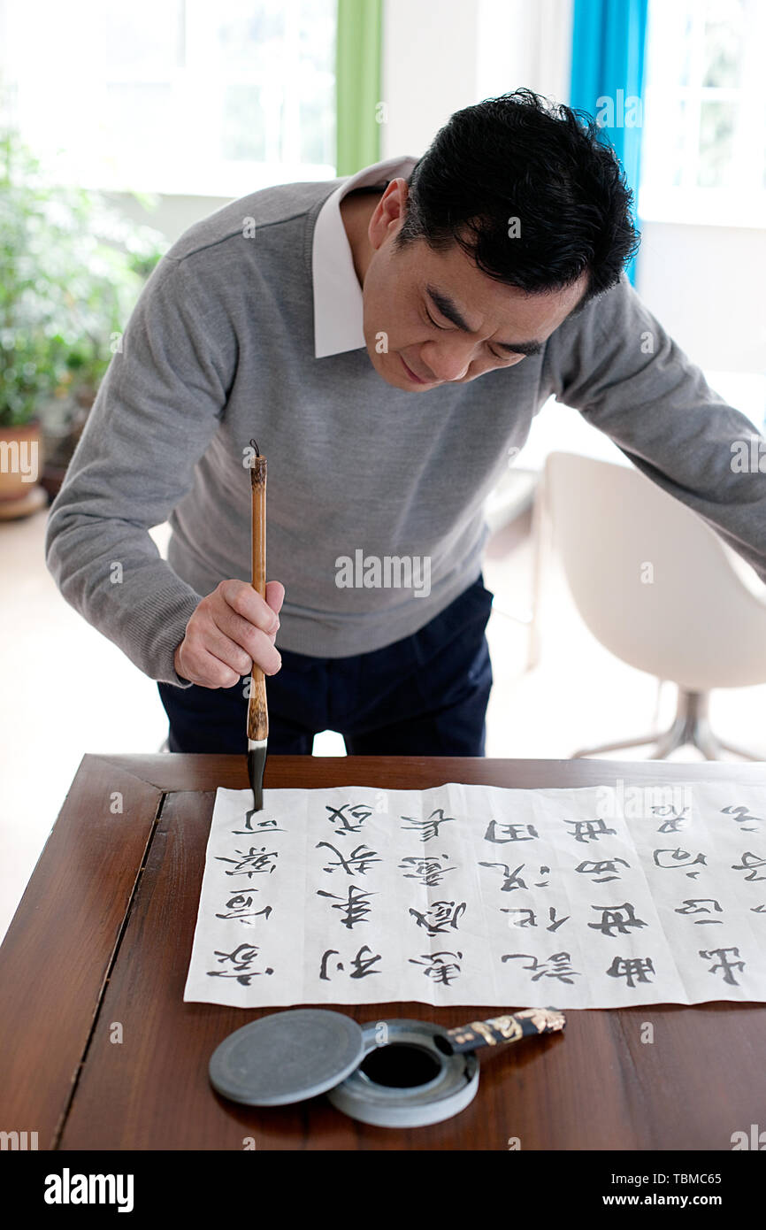 An elderly man practicing calligraphy Stock Photo