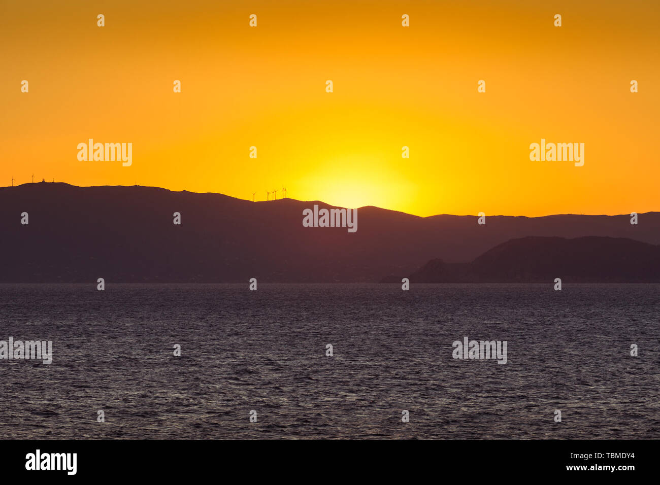 Sunset on the Saronic Gulf islands dotted with wind turbines Stock Photo
