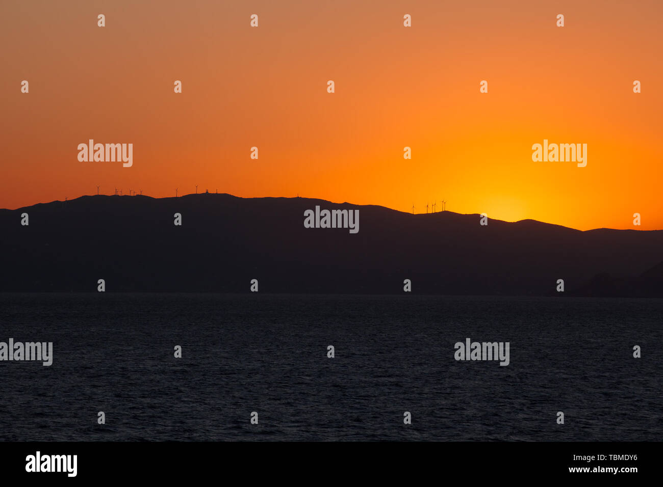 Sunset on the Saronic Gulf islands with wind turbines Stock Photo