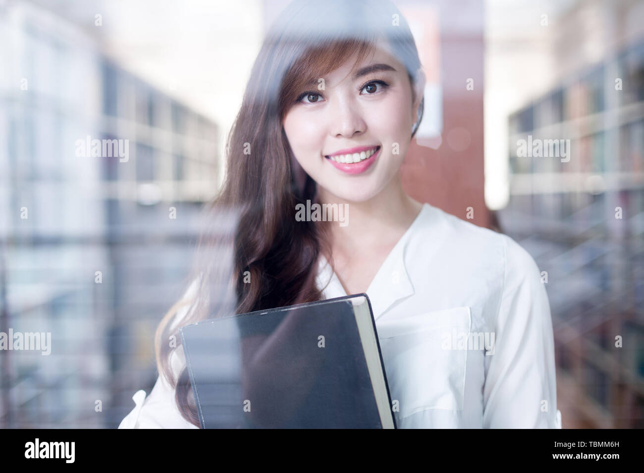asian beautiful female student holding book in library portrait Stock ...