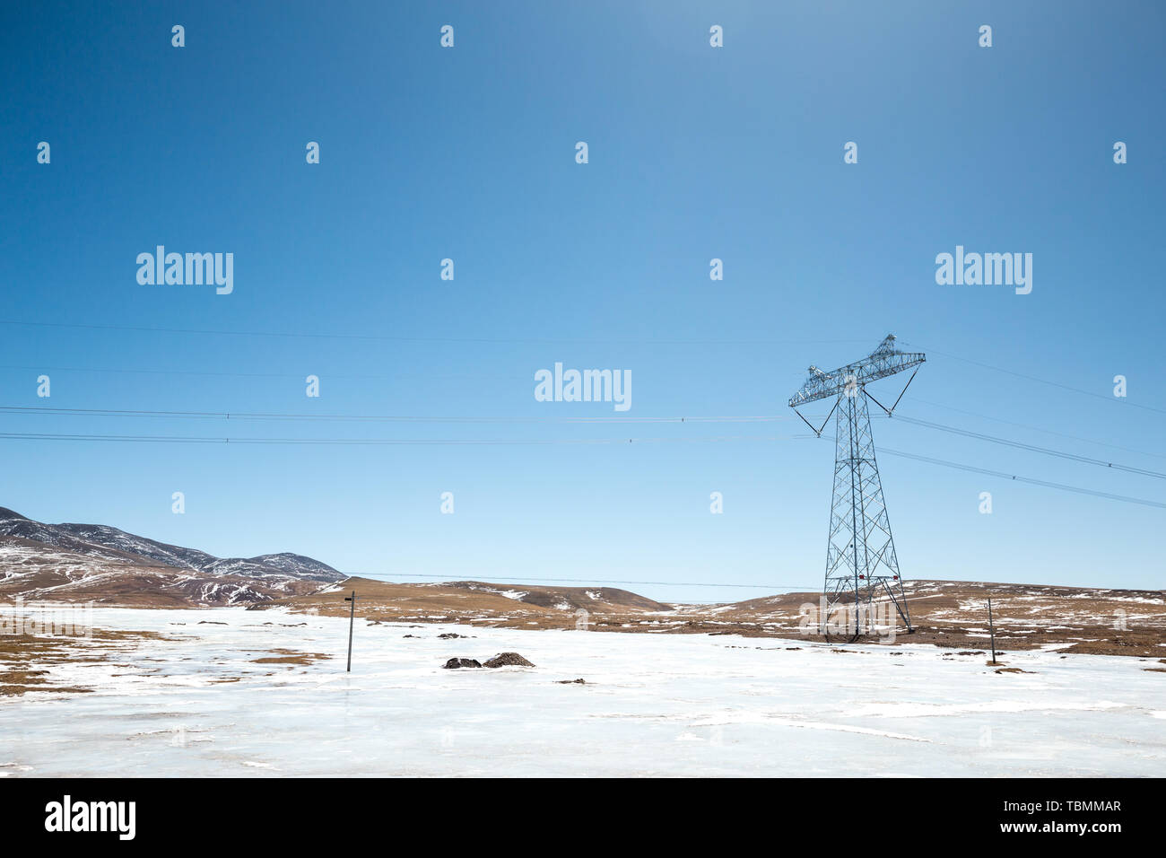 Power pylon in wild field with snow Stock Photo - Alamy