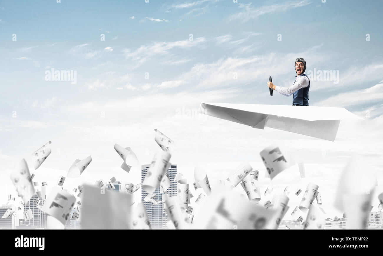 Aviator driving paper plane above business center Stock Photo - Alamy