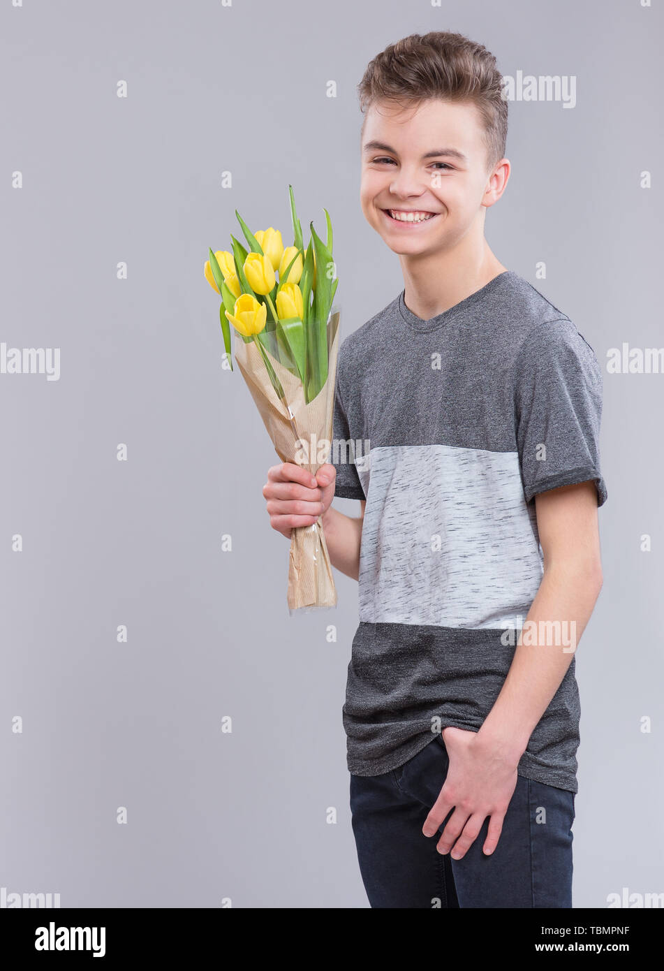 Boy with flowers on gray Stock Photo Alamy