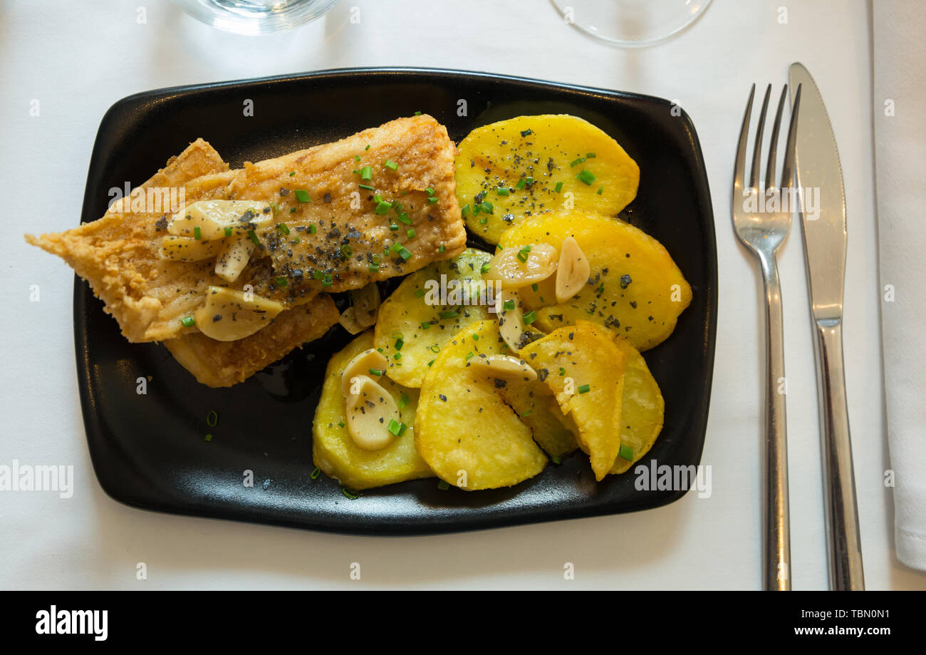 Top view of pan fried skate wings and potatoes baked with garlic