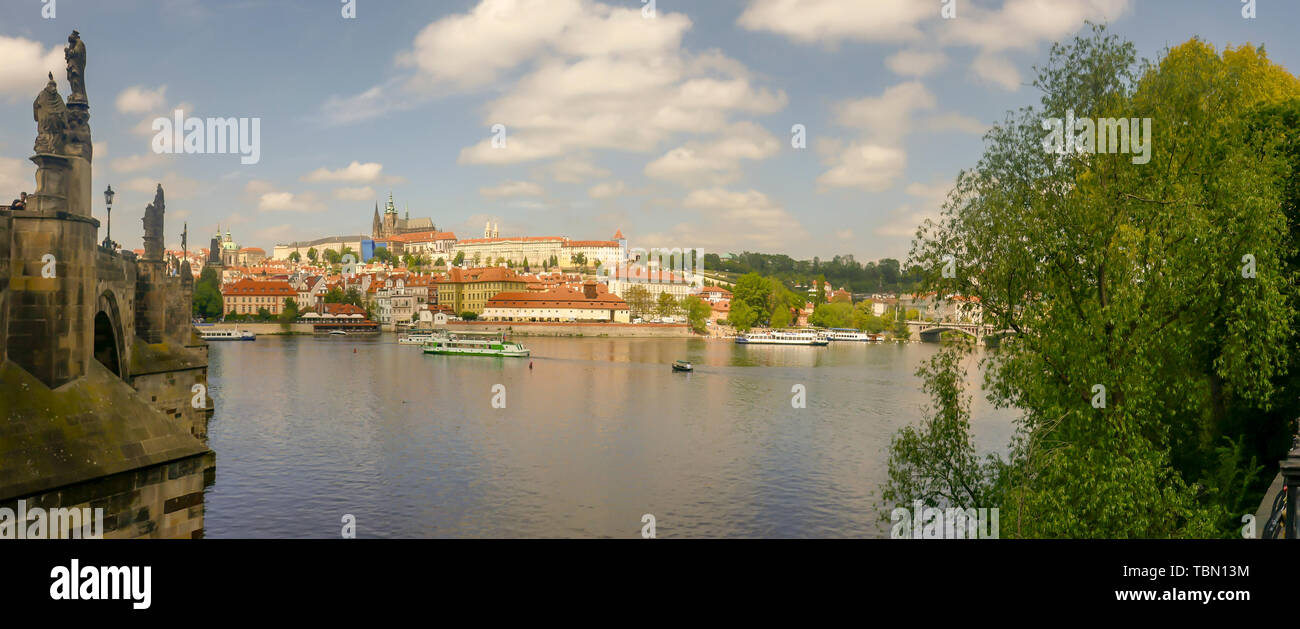 Prague, Czech Republic - May 18, 2019 :    Panorama of Lesser Quarter on Vltava waterfront and Charles Bridge with tourists sightseeing boats in Pragu Stock Photo