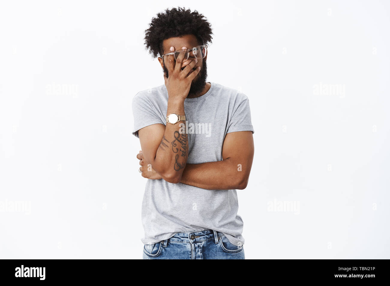 Oh gosh what humiliation. Portrait of irritated and annoyed tired african american male being embarrassed with drunk friend making facepalm gesture wi Stock Photo