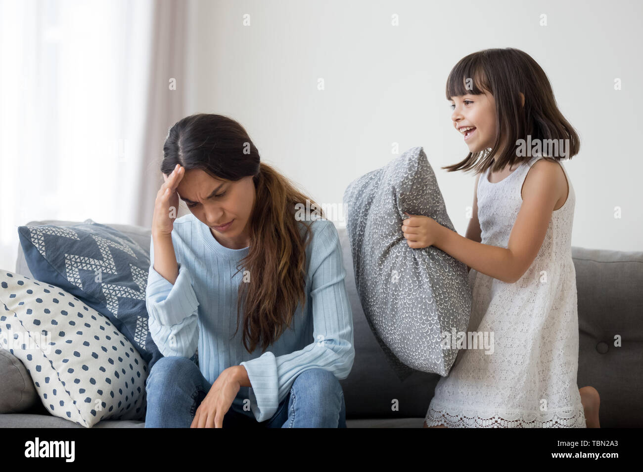Stressed mom suffer from headache annoyed by loud child Stock Photo