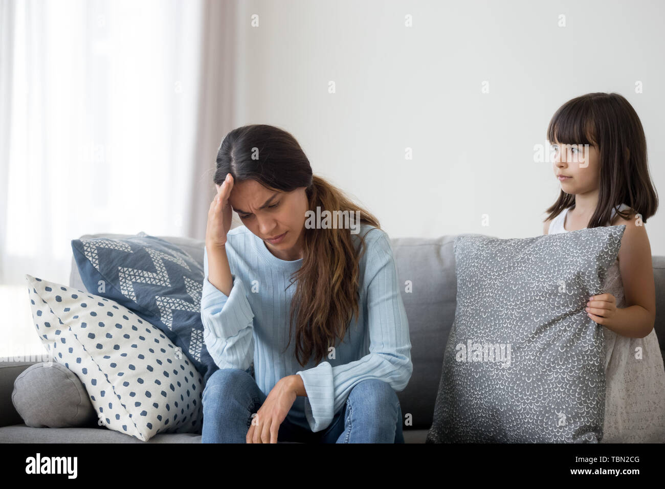 Little child confused by mom suffer health problem feel unwell Stock Photo