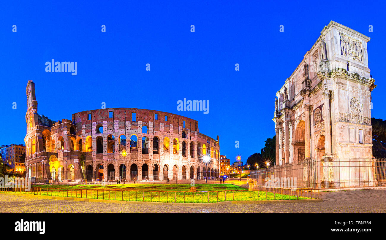 Rome, Italy: Night view of  The Arch of Constantine next to the Colosseum after sunset over a blue sky. Colosseum is an elliptical amphitheatre or the Stock Photo