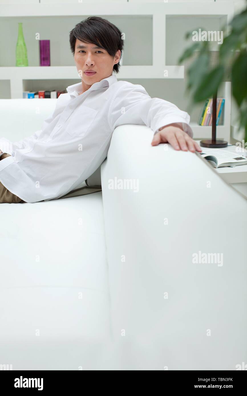 Young man sitting living room hi-res stock photography and images - Alamy