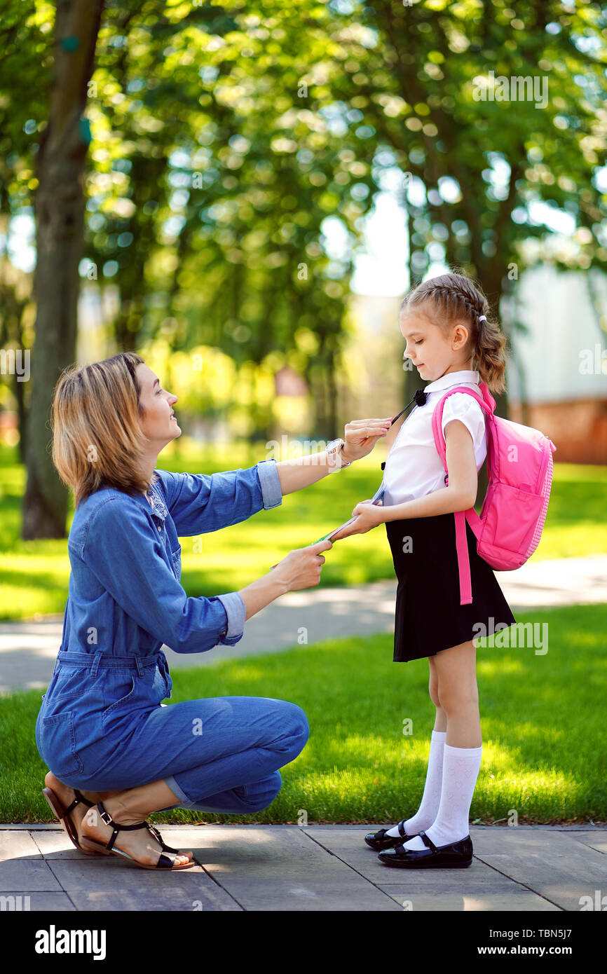 First Day At School Mother Leads A Little Child School Girl In First Grade Woman And Girl With Backpack Behind The Back Beginning Of Lessons First Day Of Fall Stock Photo