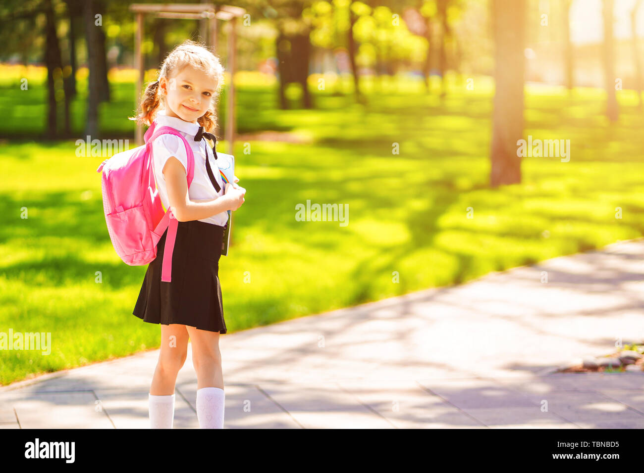 Beautiful little girl with backpack walking in the park ready back to ...