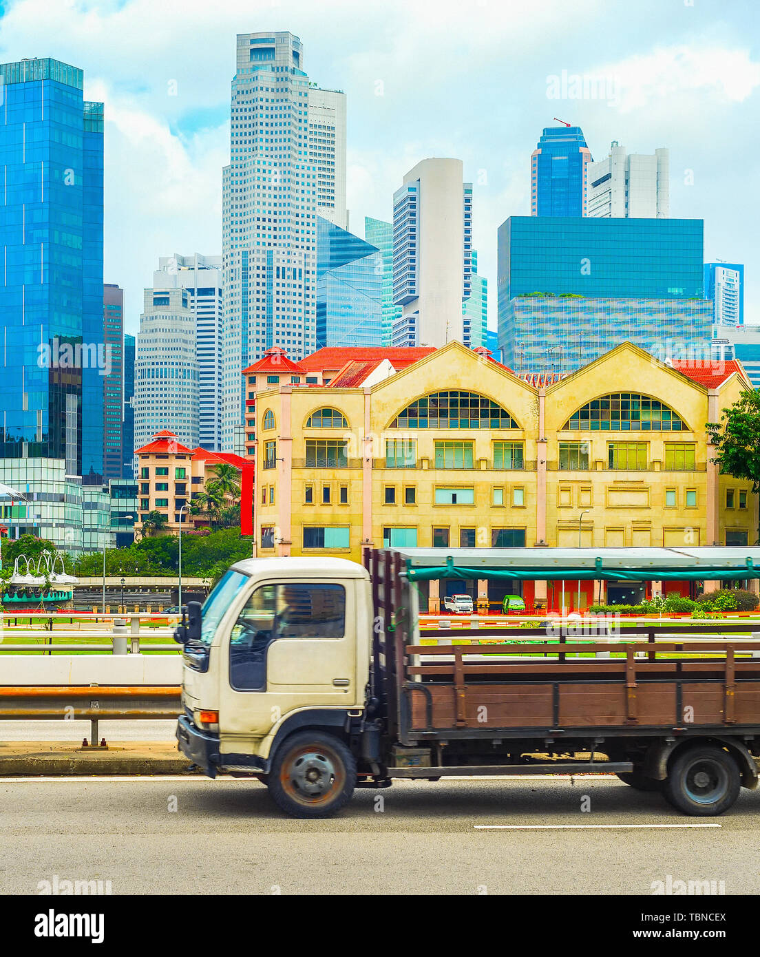 Truck on a highway passing by Singapore downtown cityscape with skyscrapers of modern architecture Stock Photo