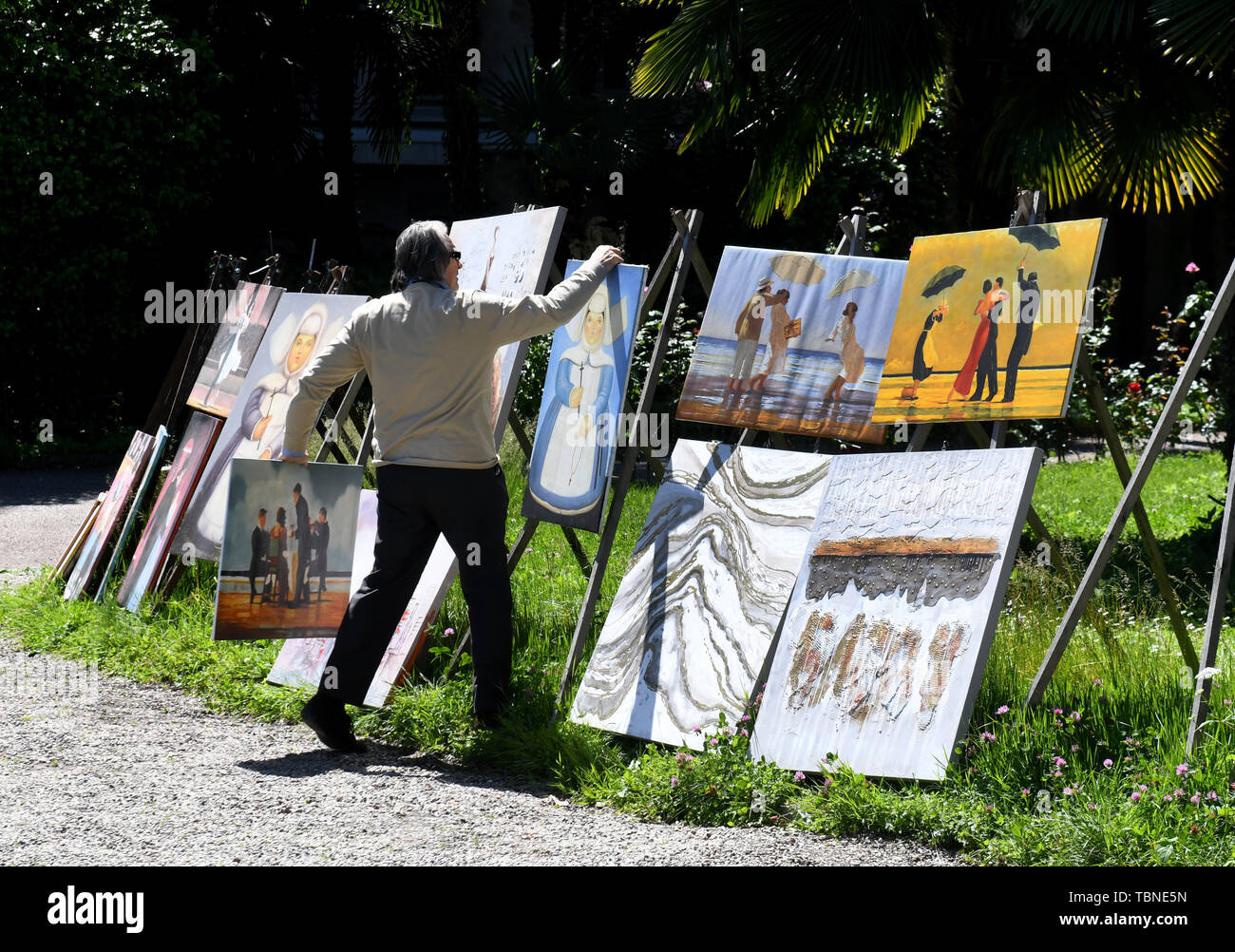 Artist man selling copies of well known art works paintings in Stresa, Italy, 2019 Stock Photo