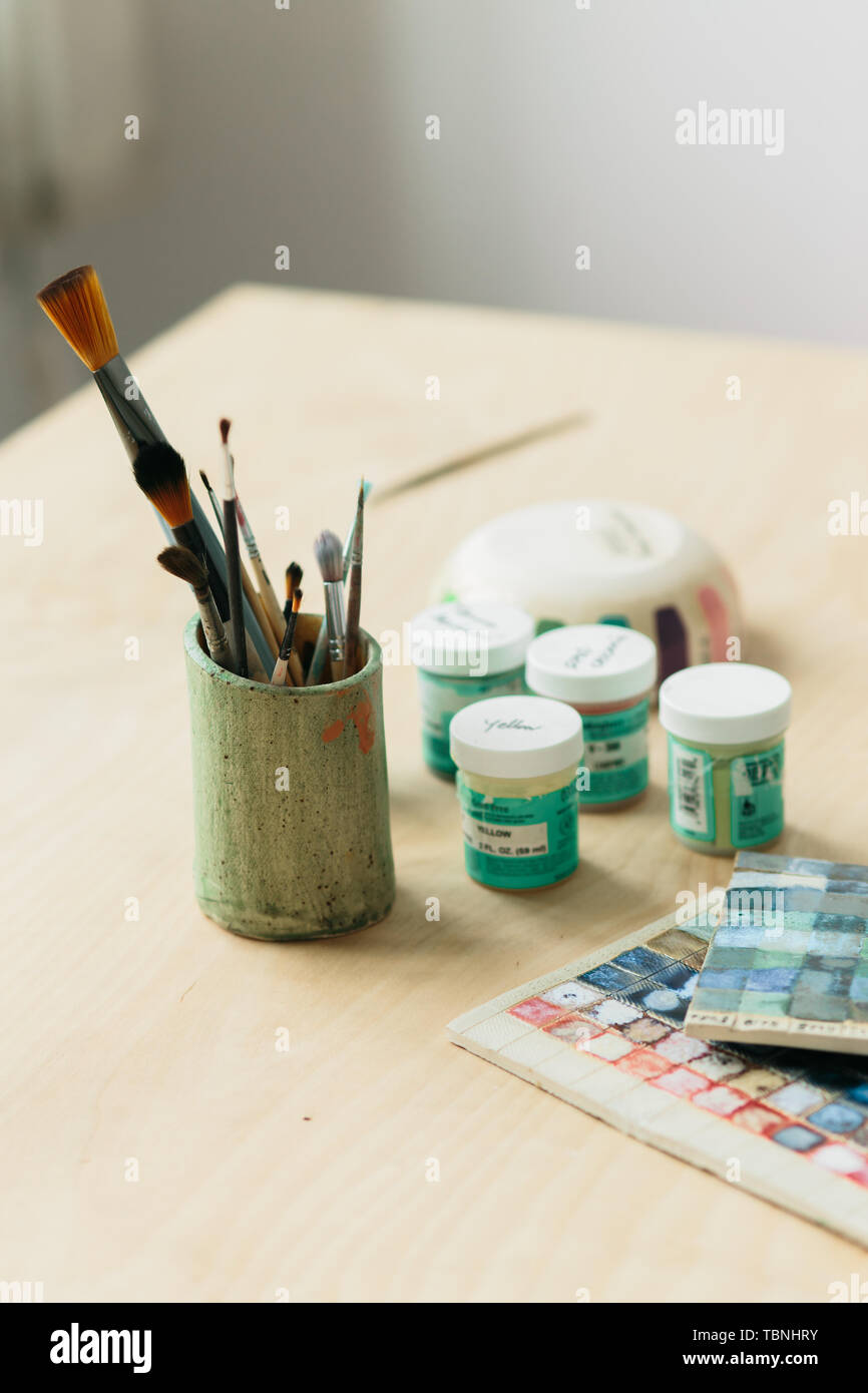 Potter holds the color palette glazes for coating ceramic products on