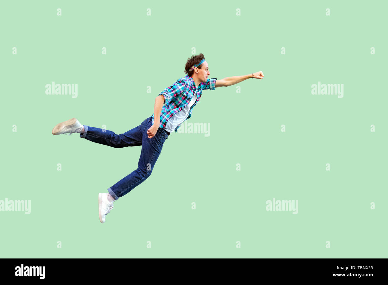 superman flying. Enthusiasm concept. Full length profile side view of young man in casual style felt himself a superhero or super man and flying. indo Stock Photo