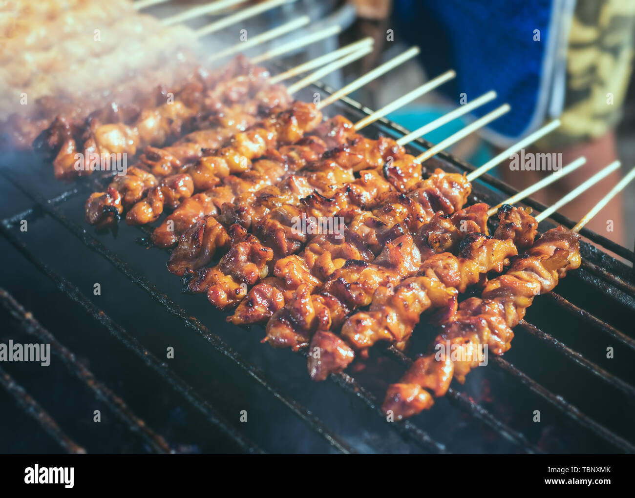 Grilled skewer chicken meat with charcoal flame in street food style