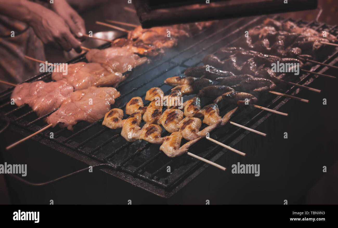 Grilled skewer chicken meat with charcoal flame in street food style