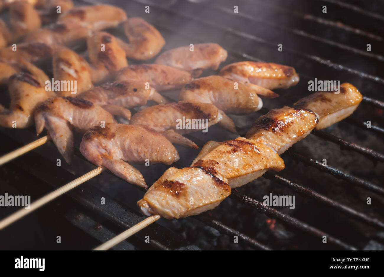 Grilled skewer chicken meat with charcoal flame in street food style