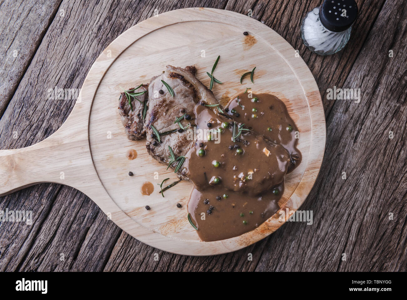 Pepper beef steak with herb and seasoning gravy sauce serve in wooden