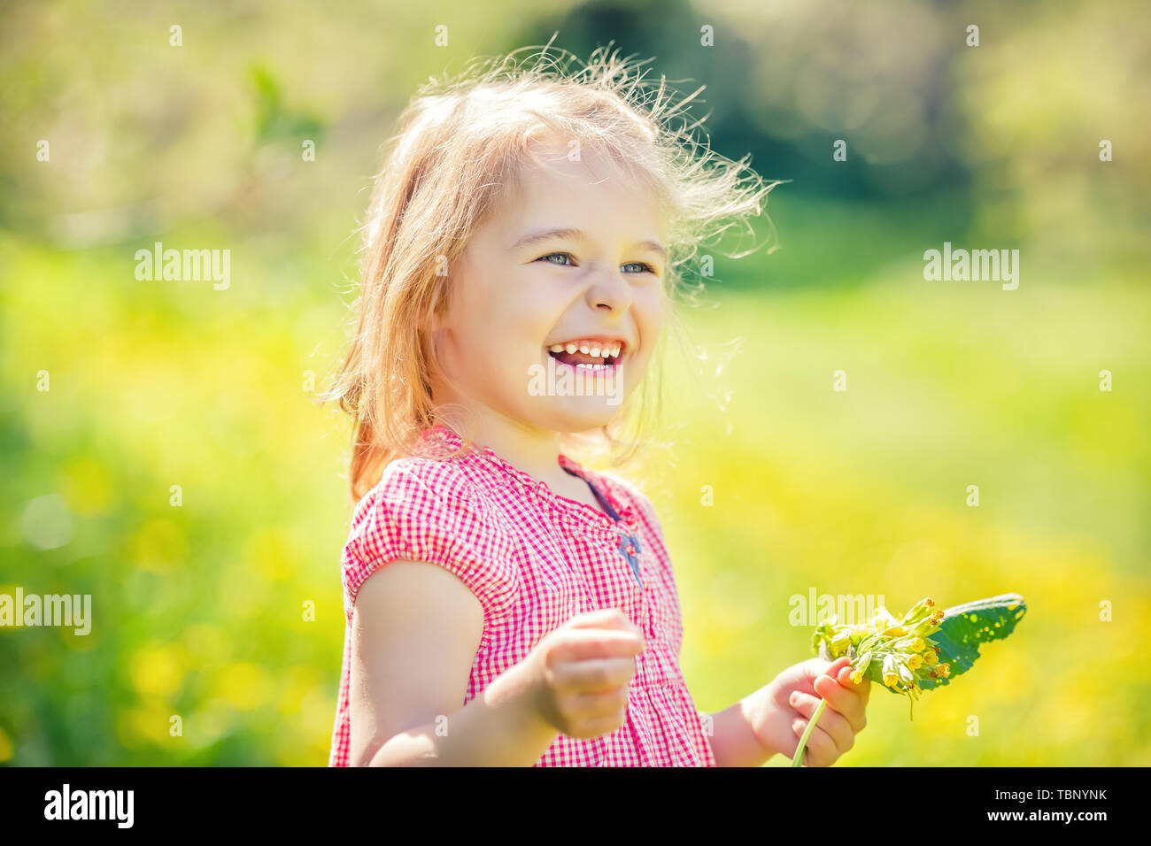 Happy little girl in spring sunny park Stock Photo - Alamy