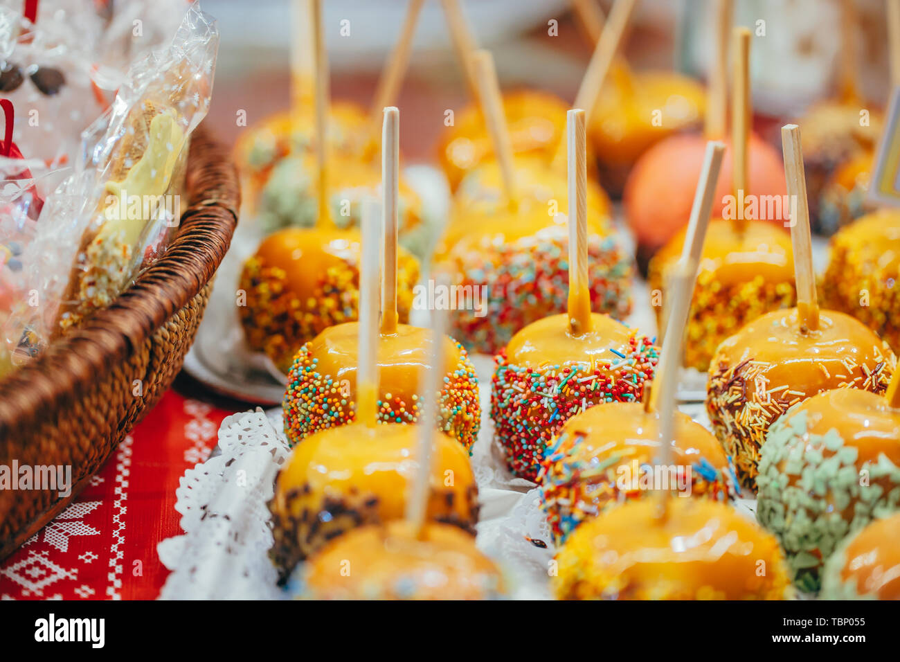 Apples in caramel and sprinkles. Street food Stock Photo Alamy