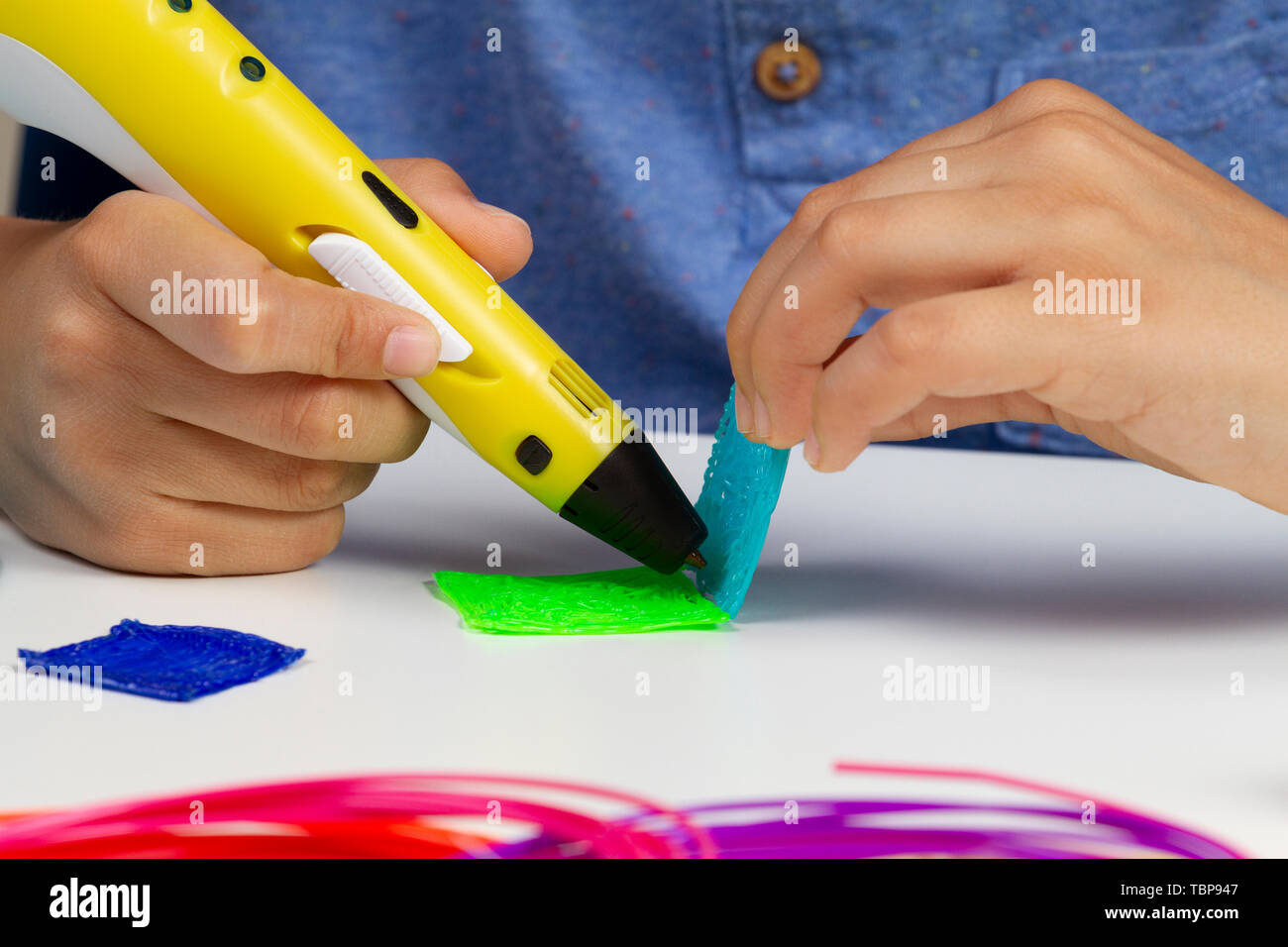 Kid hands creating with 3d printing pen new item Stock Photo - Alamy