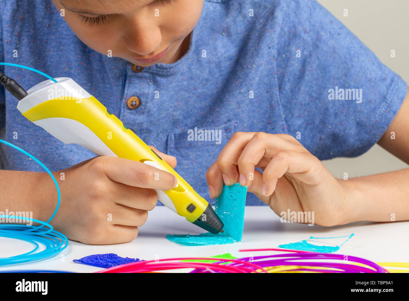 Kid with 3d printing pen creating new item Stock Photo - Alamy