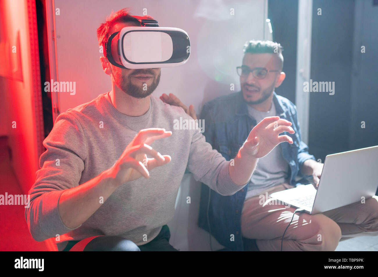 Startup IT engineers using virtual reality simulator while studying options of modern technology in innovative scientific lab Stock Photo